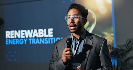 Man, speaker and mic with speech at conference for renewable energy transition at seminar. Person, public speaking and awareness for climate change, eco friendly solution and expo for hydrogen fuel