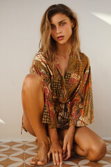 Natural light portrait of a woman in a see-through lace mini dress looking down thoughtfully. A blend of intimacy and fashion captured in golden hour tones.