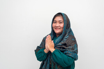 Smiling Woman in Teal Dress and Headscarf, Hands in Prayer Posit