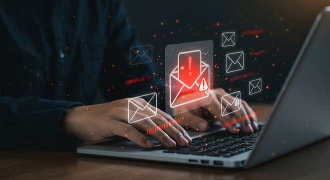Person typing on a laptop with email icons and alert symbols indicating a potential security threat business.selling ,purchasing,agreement 