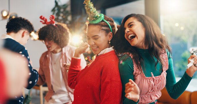 Christmas, dance and party with friends in home for celebration, festive season and laugh. Bonding, xmas holiday and reunion with group of people in living room for entertainment and social event