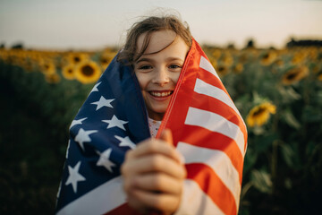 a little girl holding a flag in a field of sunflowers