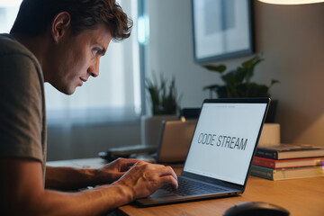 a man is typing on a laptop