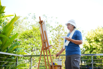 Happy Senior Asian Woman Painting Outdoors, Happy Elderly Female Artist Enjoying Nature, Creative...