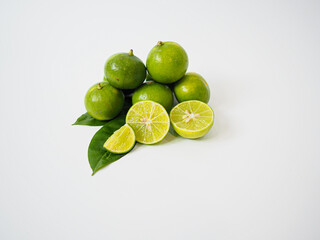 Trio of lime fruits captured at slight angle with soft shadows and organic color tones for culinary or nutrition-based content