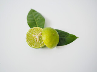 reen lime with leaf and one cut half showing texture and freshness for culinary use