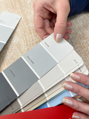 Close-up of a woman's hand choosing a color for her house.