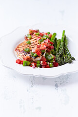 Grilled chicken fillet with asparagus and tomato salsa. Close up.	