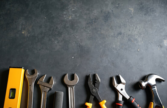Construction tools on grey-black cement floor. Home repair maintenance renovation concept. Repairing, building, renovation, construction, home improvement, DIY concept. Tools on the table. Top view.