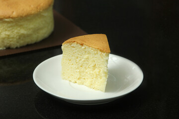 Slice of Japanese cotton cheesecake on a white plate. 