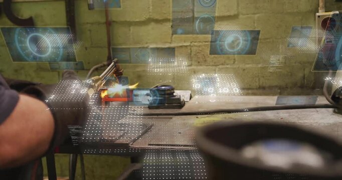 Metalworker igniting oxy torch cutting seam in metal block while monitoring data holograms