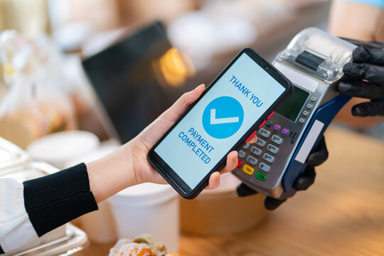 Woman Using Mobile Phone Payment to Transfer Money to bakery Shop Seller.NFC QR code device,payWave,contactless payment code for fast digital transaction,Online banking app on mobile phone,paperless