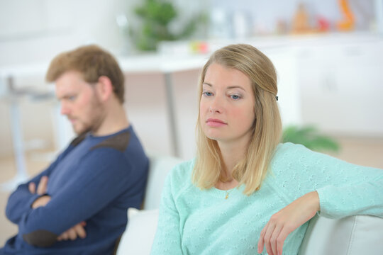 Couple sat apart, looking miserable