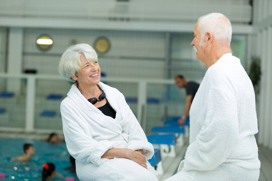 senior couple relaxing by swimming pool