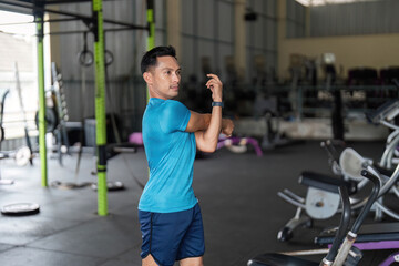 Fitness Warm-Up: Man Stretching Arm in Gym