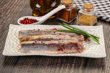 Salted marinated herring fillet with spices