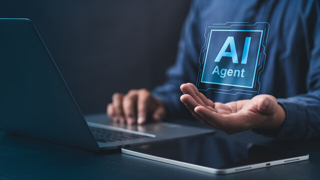 Businessman using laptop with AI Agent hologram. Concept of artificial intelligence, digital assistant, machine learning, automation, and smart technology for modern business solutions.