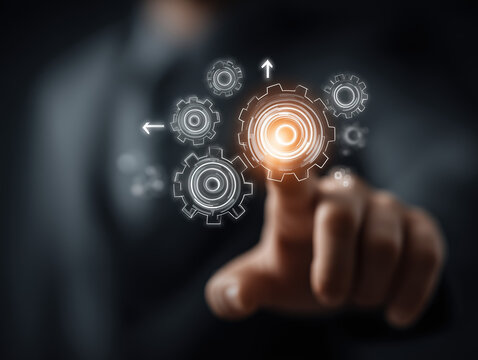 Businessman touching a glowing digital interface with interconnected gears and arrows symbolizing workflow automation