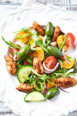 Healthy Salad with Chicken Breast, Cherry Tomatoes, Cucumber, Rocket and Green Olives. Top view.	