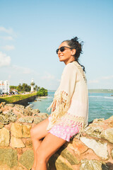 Woman tourist sit enjoy panoramic Lookout from UNESCO Galle Fort. Galle Fort Walk with Ocean Views concept. Sightseeing landmark and popular visit destination in Sri lanka