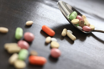 pills scattered on a dark background, medical topic dosage of medicine, concept of stress medicine
