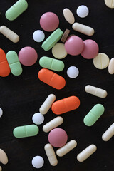 pills scattered on a dark background, medical topic dosage of medicine, concept of stress medicine