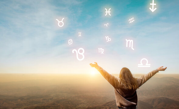 Woman raising hands looking at the sky. Astrological wheel, choose a zodiac sign. Astrology and horoscopes concept.