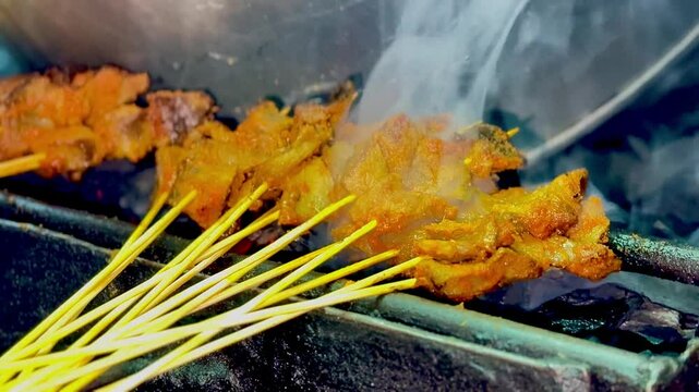 Sate Padang or Padangnese skewers being grilled at a street vendor.