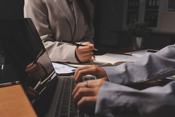 Fototapeta premium Group of confident business people point to graphs and charts to analyze market data, balance sheet, account, net profit to plan new sales strategies to increase production capacity.