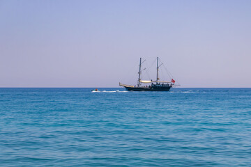 Tekirova, Turkey - June 7, 2025: Sailboat with people sails through the Mediterranean sea, crystal turquoise water