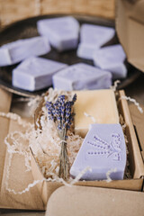 Handmade lavender soaps packed in kraft boxes with shredded filler in a cozy workspace. Home-based business, handmade skincare, small batch production, eco-friendly packaging