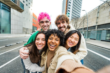 Happy multiracial friends having fun on city street - Group of young people smiling at camera outside - Friendship concept with guys and girls walking in downtown road	