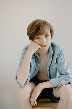 Boy resting chin on hand with a serious expression