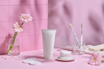 A serene bathroom scene showcases soft pink tones, fresh flowers