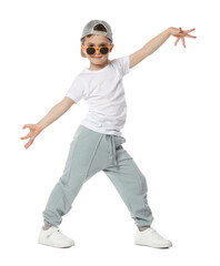 Cute little boy in sunglasses and baseball hat dancing on white background