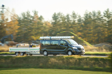 Black van transporting goods in countryside