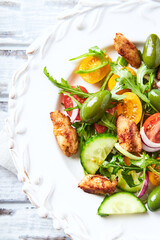 Healthy Salad with Chicken Breast, Cherry Tomatoes, Cucumber, Rocket and Green Olives. Top view.	