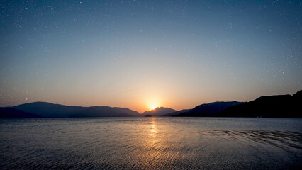 a a movement of stars in the night sky with the view of mountains..