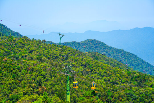 Skyrail yellow able car ride through lush green rain-forest mountains