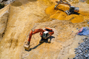 Aerial view directly above an industrial dumper truck or earth mover vehicle with muddy soil and...