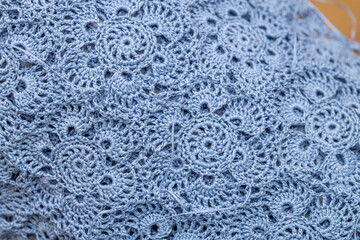 Close up of hands of unrecognizable woman knitting handmade clothes with spokes using  wool yarn....
