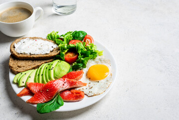 Healthy breakfast - fried egg, salmon, avocado and green salad