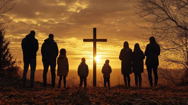 People gathered at sunset for a prayer service under a cross, standing close to one another in a circle.