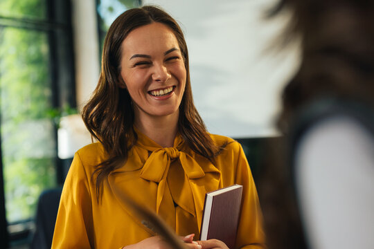 Gen z businesswoman laughing during a conversation in the office