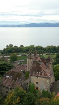 Vertical, aerial: Vaumarcus Castle and Lake Neuchatel during the day in canton of Neuchatel, Switzerland, push in drone shot