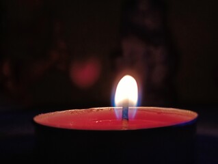 A Single Lit Tealight Candle in the Dark
