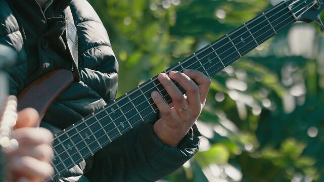 Close-up of musician playing six-string bass guitar, Live Performance Concept