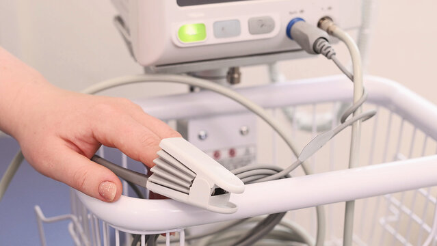pulse oximeter with blood pressure measurement function close-up measuring saturation of an overweight patient. medical vital signs monitor female hand and finger close-up. Diabetes diagnostics - Powered by Adobe