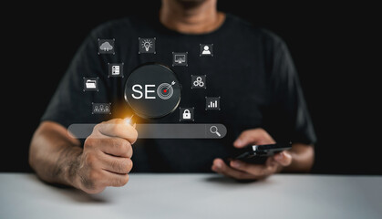 Focused individual analyzing search engine optimization with digital tools and a smartphone in a...