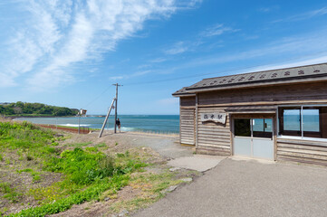 【青森県深浦町：JR五能線驫木（とどろき）駅】海辺にたたずむひなびた駅舎の風景。駅舎の看板の文字は「とどろきえき」という駅名